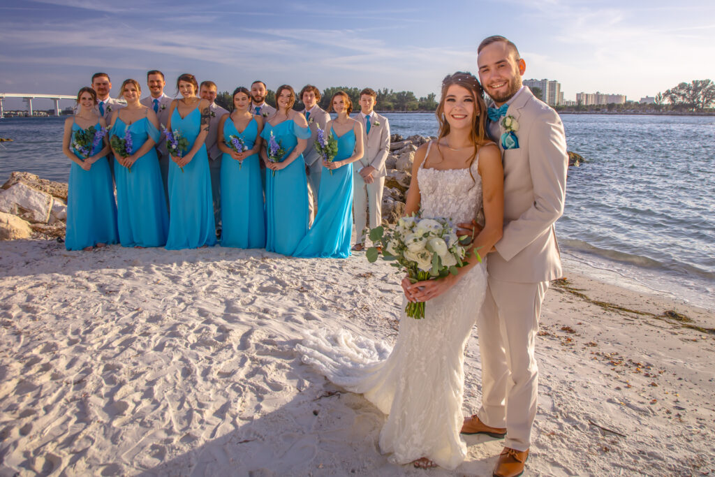bride and groom with bridal party on the beach
