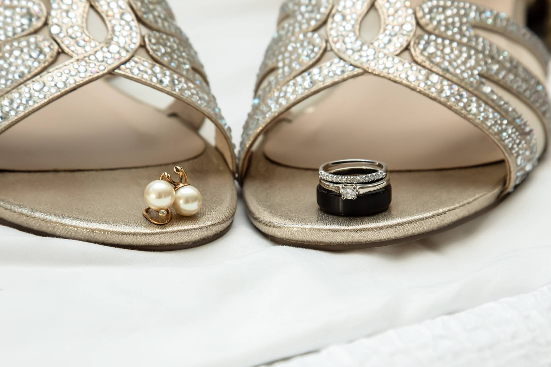 brides jewelry sitting on the tip of her shoes