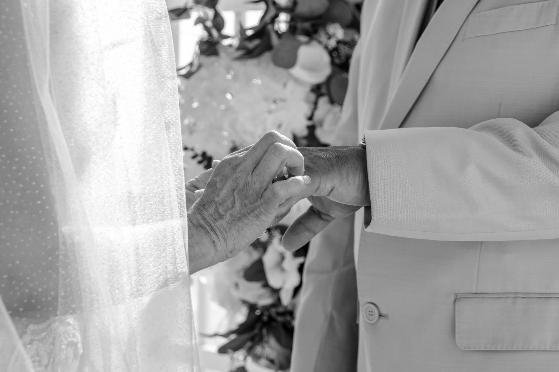bride putting wedding band on the groom during beach wedding ceremony